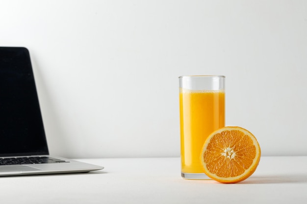 Vers sinaasappelsap in een glas Vers geperst Op tafel met laptop Vitamine C