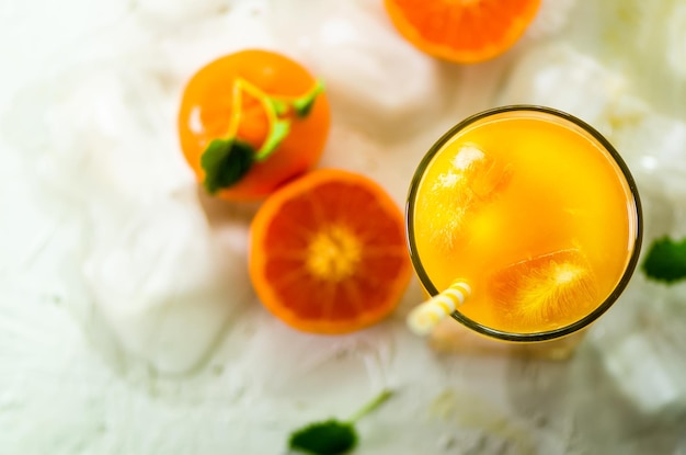 Vers sinaasappelsap in glas en mandarijnen met muntijs op witte achtergrond Bovenaanzicht kopieerruimte Warme zomerdag Vakantie