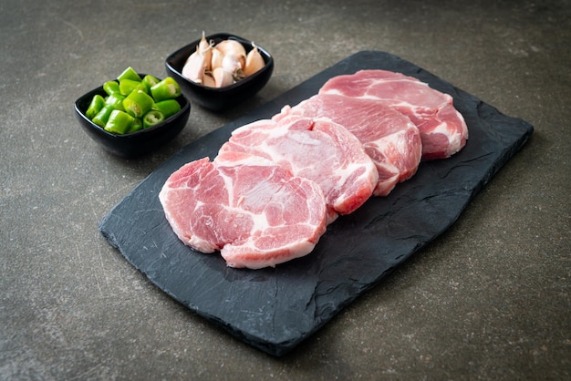 vers varkenshals rauw of kraag varkensvlees aan boord met ingrediënten voor gemarineerd