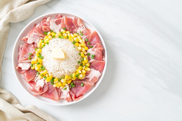 Vers varkensvlees rauw gesneden met rijst en maïs op bord en klaar om te koken