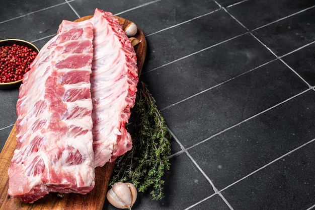 Vers Varkensvlees Spareribs Rauwe spareribs op een houten bord met tijm en kruiden Zwarte achtergrond Bovenaanzicht Kopieer ruimte