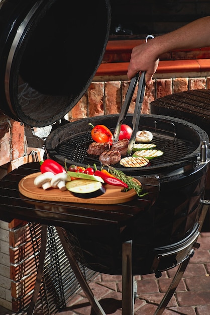 Foto vers vlees en groenten gegrild tijdens een zelfgemaakte weekendbarbecue. kookconcept, donkere keuken.