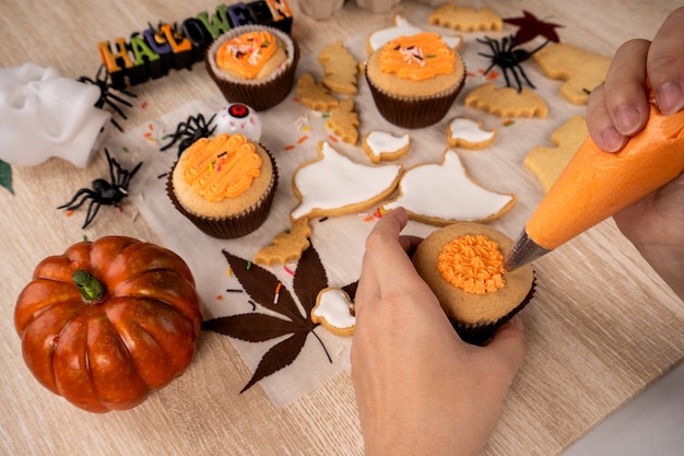 Vers zelfgemaakt versieren halloween-dessert met spook, kruipende spin, vleermuis, spookkasteel en gruwelijke oogbol op houten achtergrond, kopie ruimte