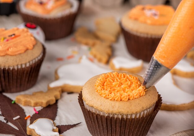 Vers zelfgemaakt versieren halloween-dessert met spook, kruipende spin, vleermuis, spookkasteel en gruwelijke oogbol op houten achtergrond, kopie ruimte