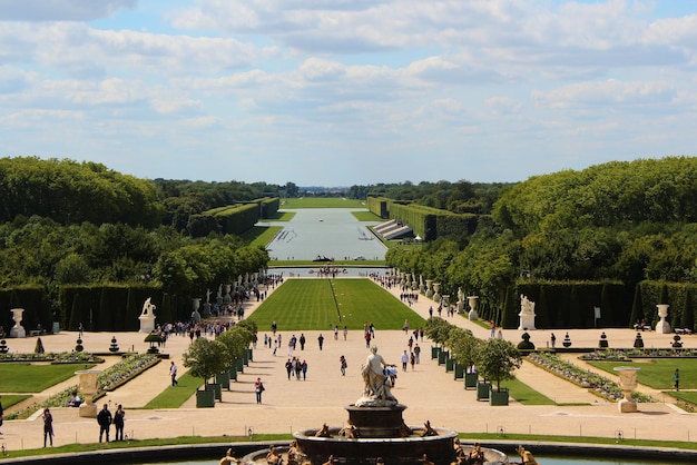 Versailles France August 26 2019 Nice panorama of the Versailles gardens from the Parterre d'Eau Visitors enjoy the landscape view from the Fountain of Latona all the way to the Grand Canal
