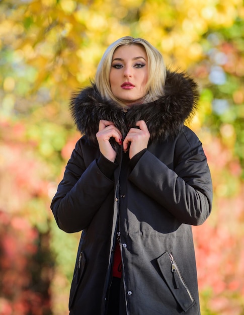 Versatile functional and stylish Girl wear parka while walk park Autumn season fashion concept Puffer jacket with hood Woman wear black parka fur hood Classic parka coat has become wardrobe icon