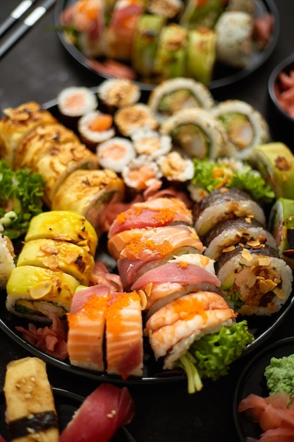 Verscheiden sushi set geserveerd op donkere donkere achtergrond Top uitzicht op zeevruchten verschillende maki rollen sashimi en nigiri met kaviaar garnalen zalm aal makreel en tonijn