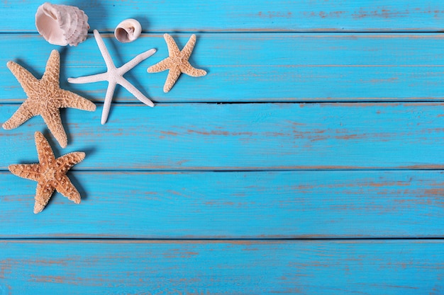 Verscheidene oude zeester doorstond de blauwe achtergrond van het strand houten dek