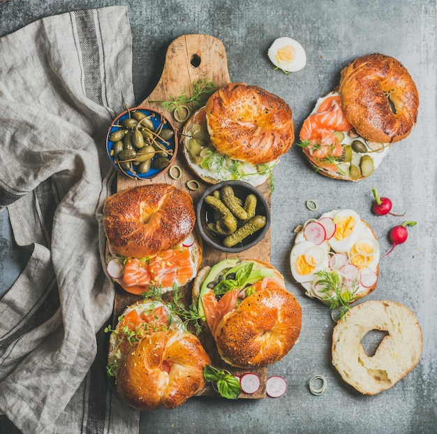 Verscheidenheid aan bagels met verschillende vullingen op rustieke houten plank