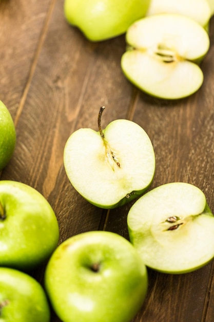 Verscheidenheid aan biologische appels gesneden op houten tafel.