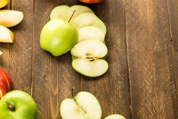 Verscheidenheid aan biologische appels gesneden op houten tafel.