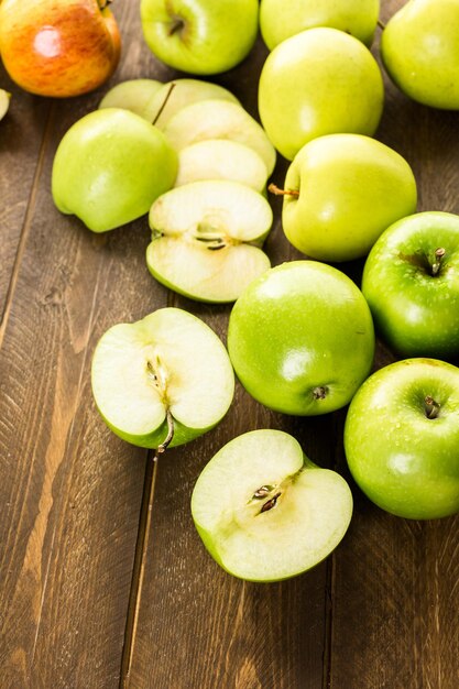 Verscheidenheid aan biologische appels gesneden op houten tafel.