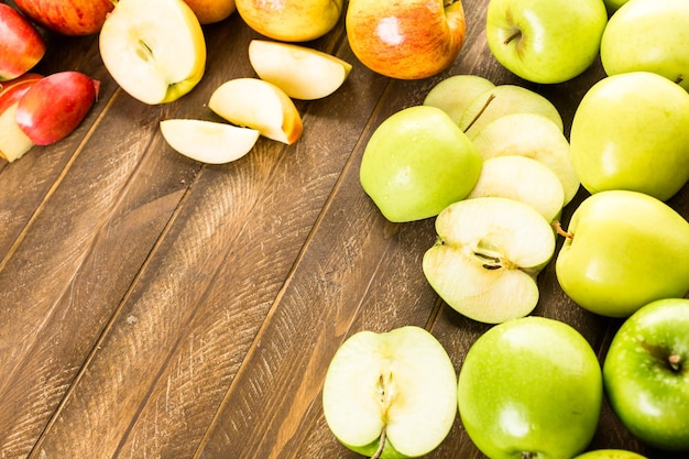 Verscheidenheid aan biologische appels gesneden op houten tafel.