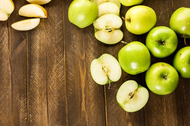 Verscheidenheid aan biologische appels gesneden op houten tafel.