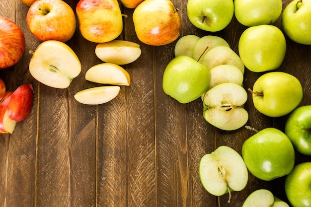 Verscheidenheid aan biologische appels gesneden op houten tafel.