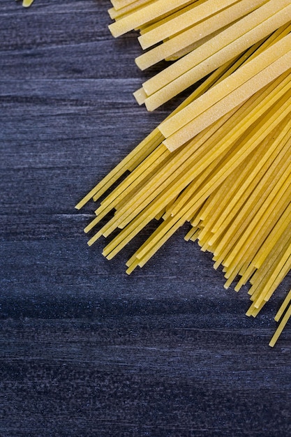 Verscheidenheid aan biologische droge pasta op een houten bord.