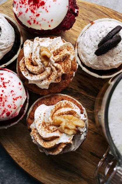 Verscheidenheid aan cupcakes met een kopje koffie op een houten tablet