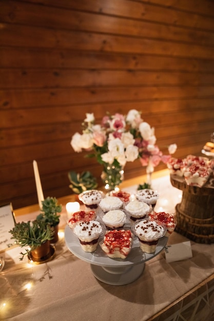 Verscheidenheid aan desserts op cakestand bij huwelijksreceptie.