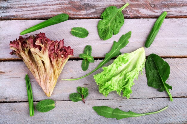 Verscheidenheid aan groene bladeren voor salade op houten tafel