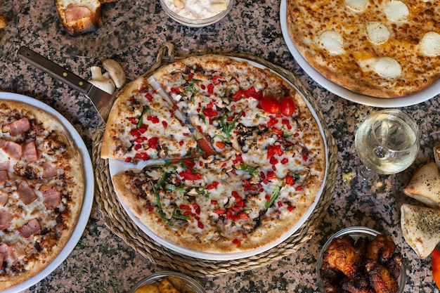 Verscheidenheid aan pizza's en tapas op granieten tafel