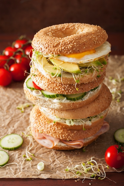 Verscheidenheid aan sandwiches op bagels: ei, avocado, ham, tomaat, zachte kaas, alfalfaspruiten