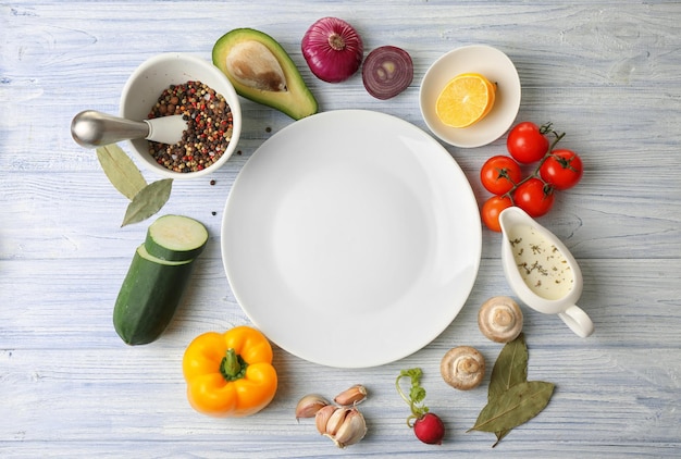 Verscheidenheid aan voedingsmiddelen en bord op keukentafel