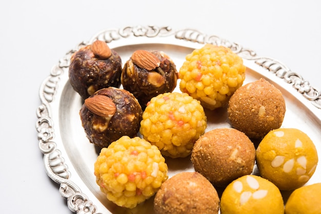 Verscheidenheid aan zoete laddu of laddoo in een zilveren plaat, een zoete knoedel bestaande uit bundi, droog fruit of rava, selectieve focus