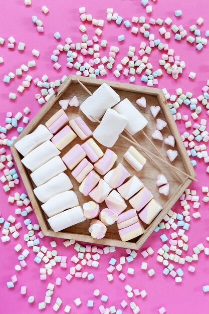 Foto verscheidenheid marshmallows charcuterie bord op roze achtergrond. close-up, bovenaanzicht.