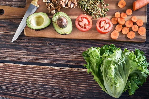 Verscheidenheid van gesneden groenten voor een salade op vintage houten achtergrond. Gezond vegetarisch eten, bovenaanzicht.