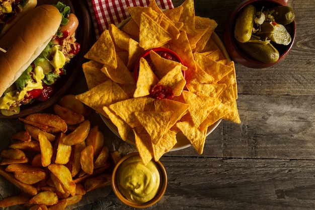 Verscheidenheid van klassieke traditionele Amerikaanse smakelijke junk ongezond eten op houten achtergrond met kopie ruimte. Hotdogs en Chips.