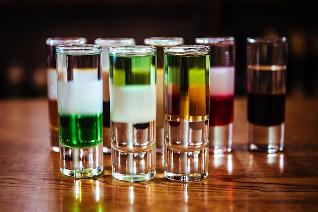 Foto verschillende alcoholische cocktails. meerlaagse korte drank op een houten tafel in een bar