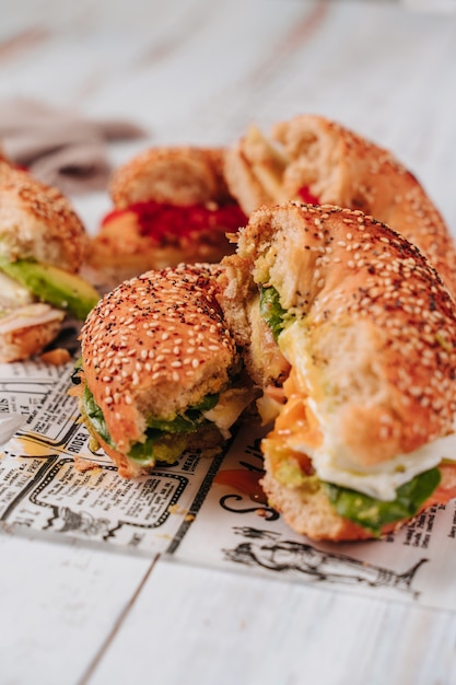 Verschillende bagels gehalveerd met sesam en chia brood, erin zitten verschillende ingrediënten zoals tomaat, ham, avocado, verse kaas, kip in reepjes.