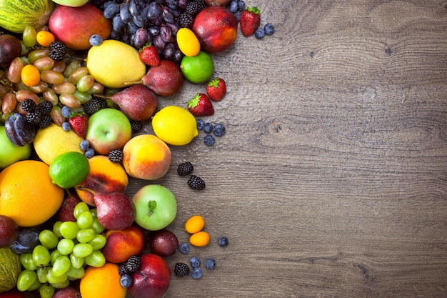 Verschillende biologische vruchten met waterdruppels op houten tafel achtergrond