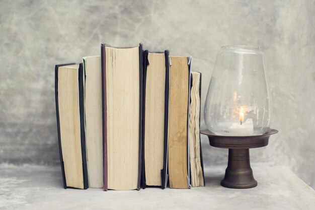 Verschillende boeken en een kaars op een tafel