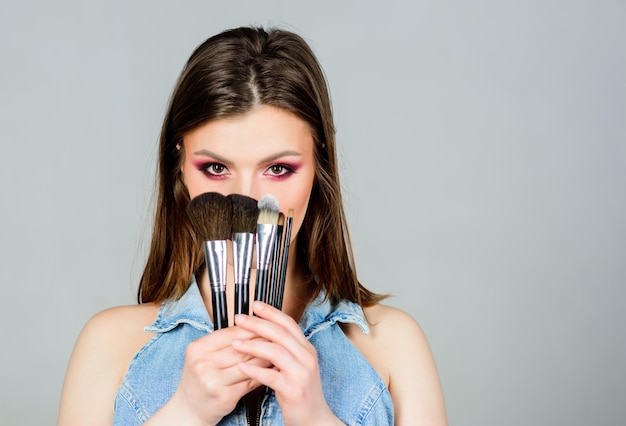 Verschillende borstels Huidverzorging Make-up cosmetica concept Huidskleur concealer Cosmetica winkel Meisje oogschaduw aanbrengen Vrouw die make-upborstel toepast Benadruk vrouwelijkheid Professionele make-upbenodigdheden