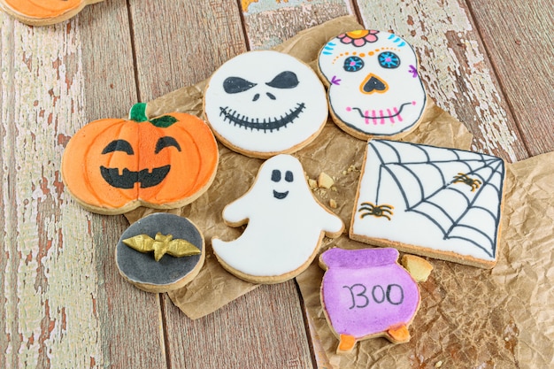 Foto verschillende boterachtige koekjes met halloween-thema op bruin papier (bovenaanzicht).