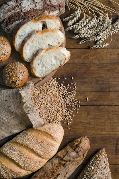 Verschillende broodproducten, aartjes en tarwekorrel op houten tafel. Vrije ruimte voor uw tekst. Rustieke stijl. Bovenaanzicht.