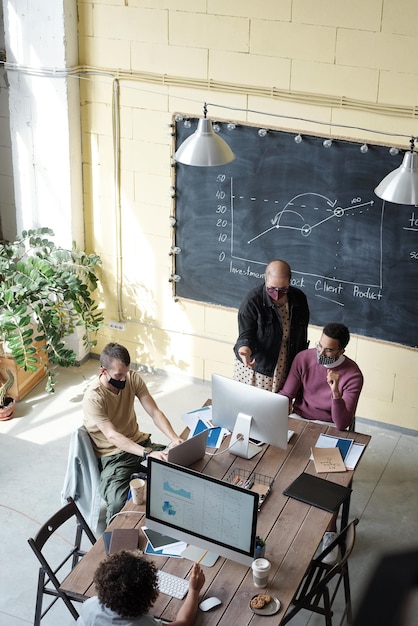 Verschillende collega's kijken naar computerschermen tijdens het werk