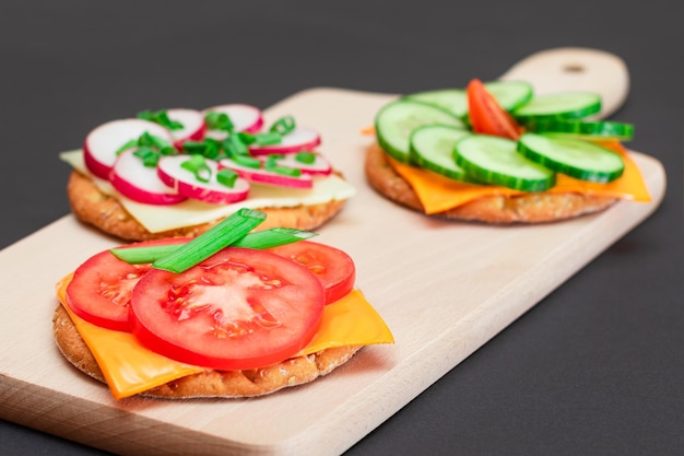 Verschillende crackersandwiches met tomatenkomkommerradijs en kaas