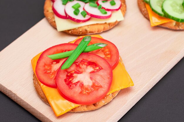 Foto verschillende crackersandwiches met tomatenkomkommerradijs en kaas