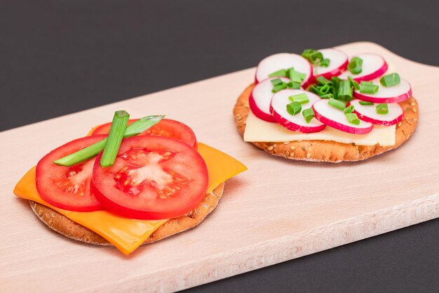 Foto verschillende crackersandwiches met tomatenkomkommerradijs en kaas