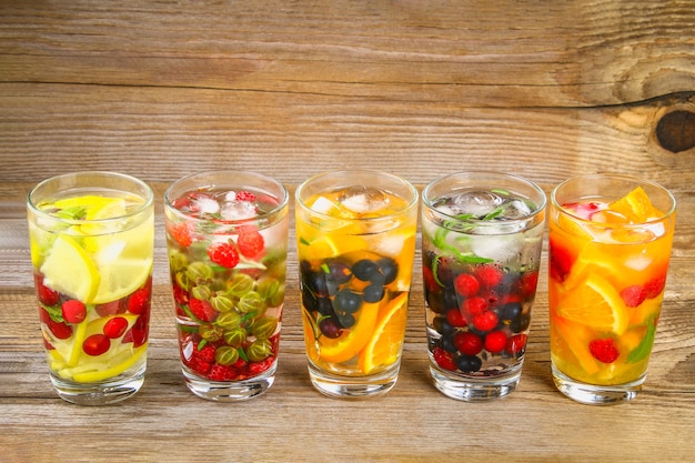 Verschillende detox water in glazen, verschillende smaken, bessen, fruit.