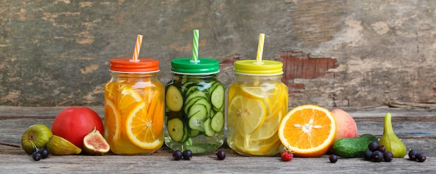 Verschillende dranken, groenten en fruit op houten achtergrond.