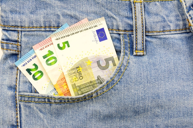 Verschillende eurobiljetten worden in de jeanszak gestoken