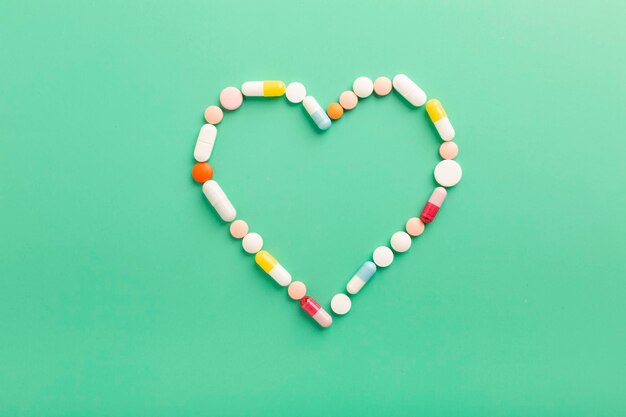 Verschillende farmaceutische tabletten en capsules voor de behandeling van hartaandoeningen Hartvorm en een fles pillen Ruimte voor tekst kopiëren