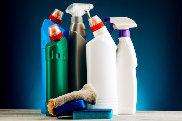 Verschillende flessen schoonmaakproducten op een blauwe achtergrond