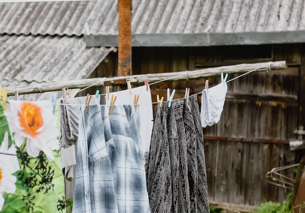 Verschillende gewassen kleren hangen aan een waslijn op landelijke tuin