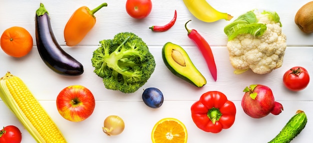 Verschillende groenten en fruit op witte houten tafel in de keuken. Gezonde voeding achtergrond. Bovenaanzicht, plat gelegd