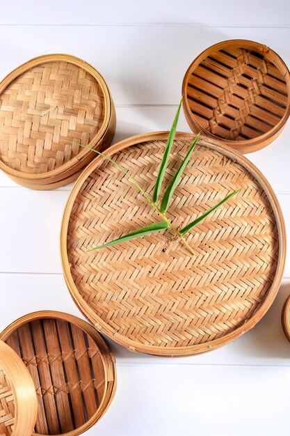 Verschillende grootte van traditionele Aziatische keuken gebruiksvoorwerp bamboe Steamer ingesteld op witte houten achtergrond. Bovenaanzicht, plat lag. Ruimte voor tekst kopiëren.