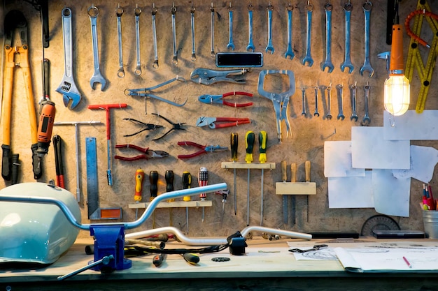 Verschillende handgereedschappen hangen op een plank in een werkplaats